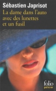 La dame dans l'auto avec des lunettes et un fusil